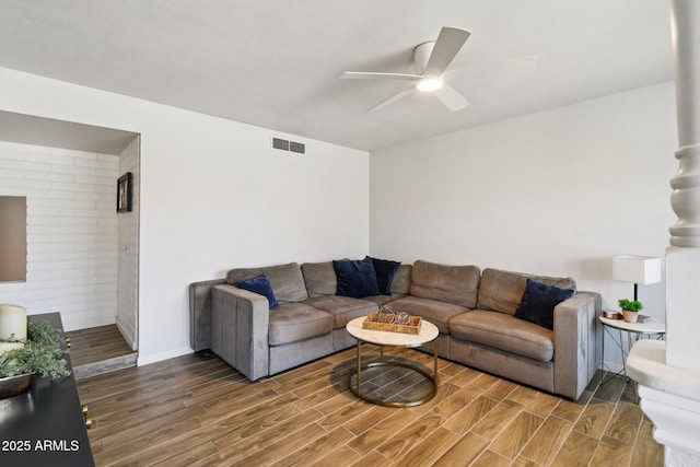 13842 N 40th Ave, Phoenix, AZ 85053 - living room featuring a ceiling fan, wood finished floors, and brick wall