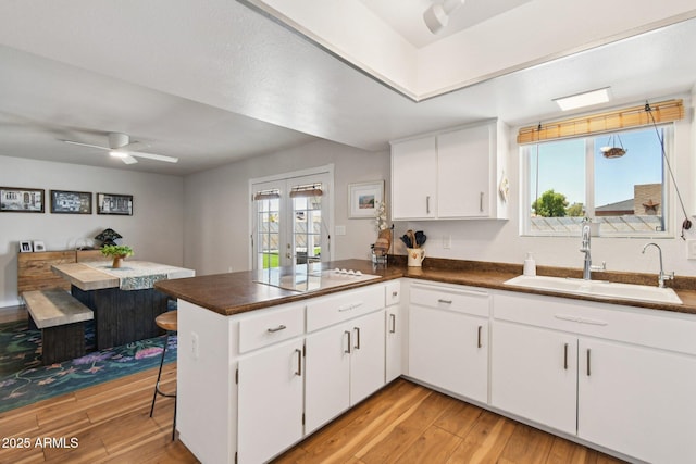 13842 N 40th Ave, Phoenix, AZ 85053 - kitchen featuring a peninsula, white electric cooktop, a ceiling fan, and light wood-type flooring