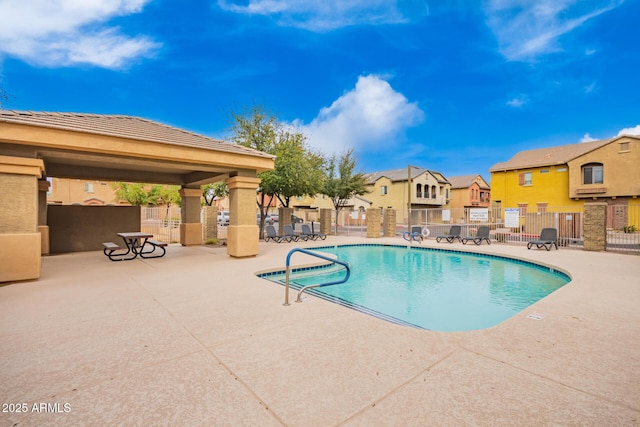pool with a residential view, fence, a gazebo, and a patio