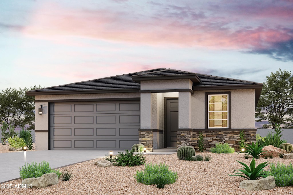 prairie-style house featuring concrete driveway, a tile roof, stucco siding, stone siding, and an attached garage