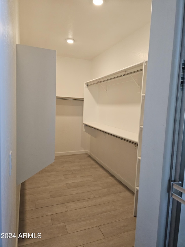 spacious closet with light hardwood / wood-style floors