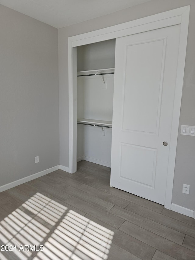 unfurnished bedroom with hardwood / wood-style floors and a closet