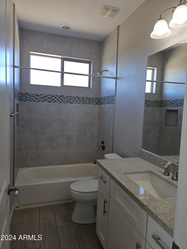 full bathroom with vanity, toilet, and tiled shower / bath