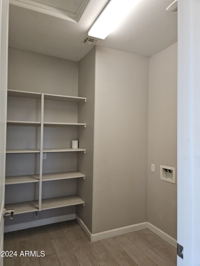 washroom with hardwood / wood-style flooring, a textured ceiling, and washer hookup