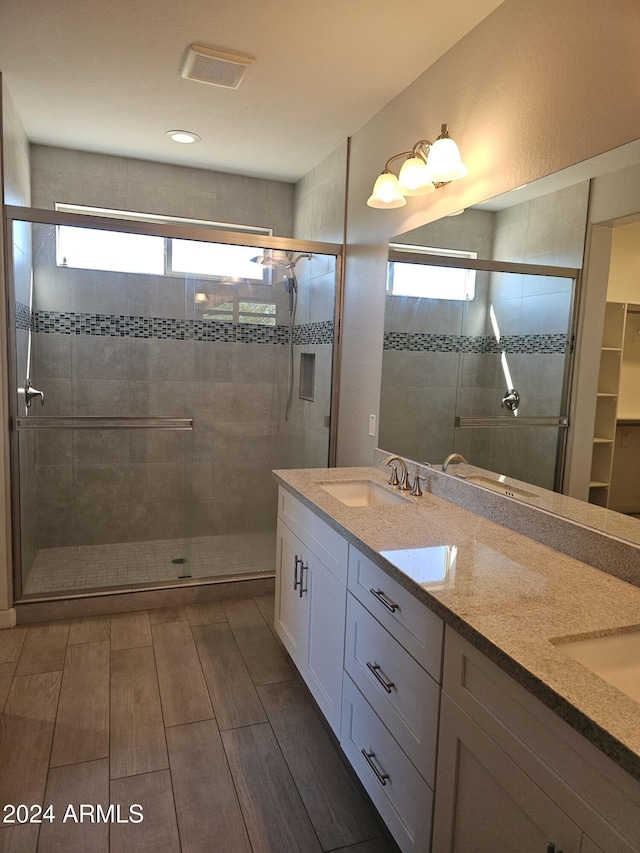 bathroom featuring vanity and a shower with door