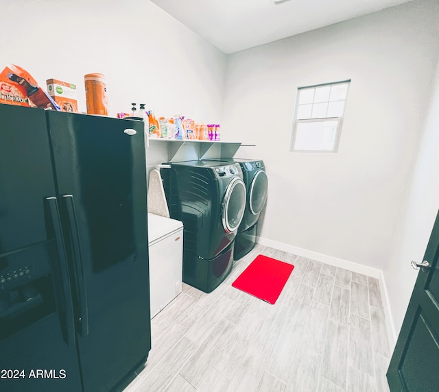 washroom with washing machine and dryer and light hardwood / wood-style floors