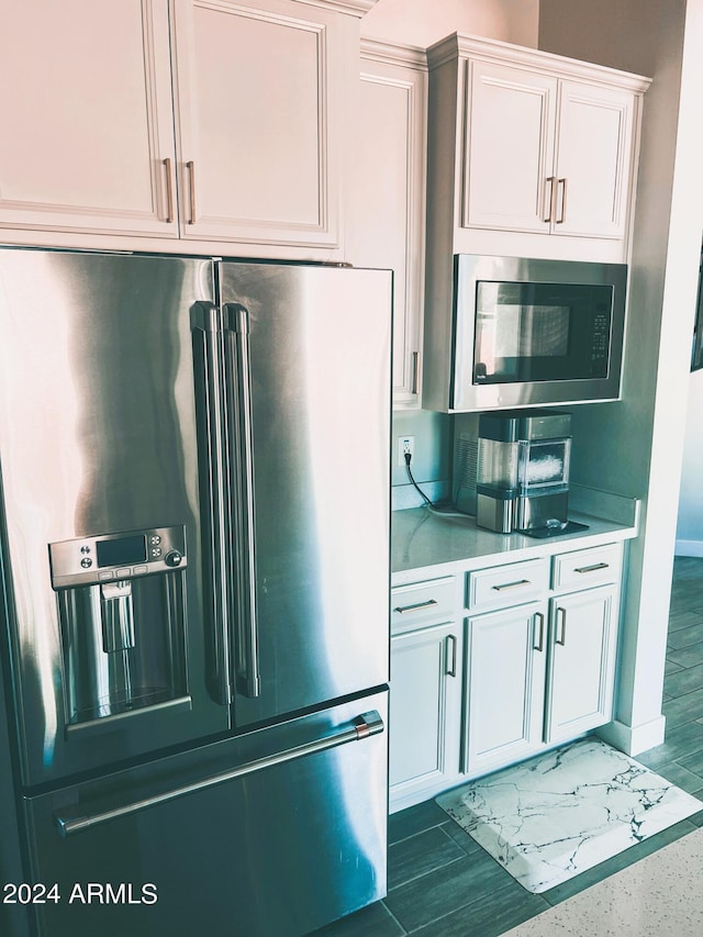 kitchen featuring stainless steel appliances and white cabinetry