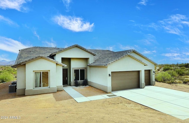 view of front of property featuring central AC unit, a mountain view, and a garage