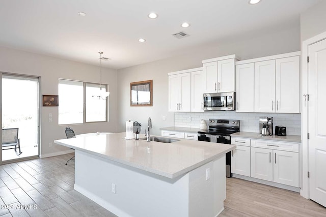 kitchen with pendant lighting, white cabinetry, sink, and stainless steel appliances