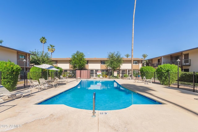 community pool featuring fence and a patio