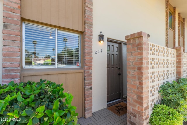 view of exterior entry featuring brick siding