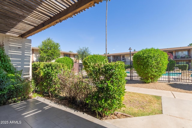 view of patio / terrace featuring fence, a pergola, and a community pool