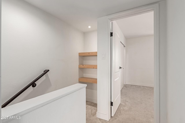 hall featuring an upstairs landing, light carpet, and recessed lighting