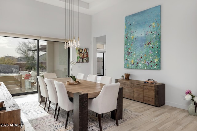 dining room with light wood-type flooring and an inviting chandelier