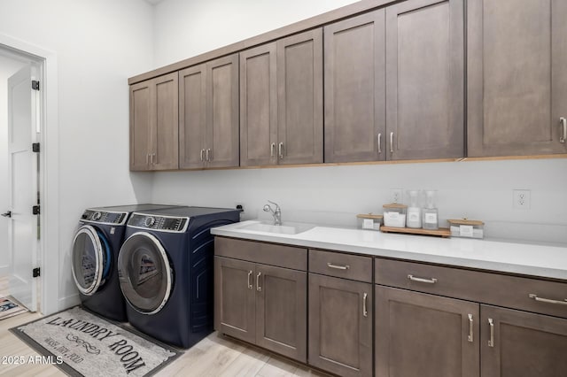 clothes washing area featuring cabinets, independent washer and dryer, and sink