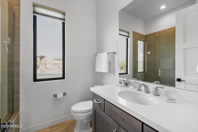 bathroom featuring vanity, an enclosed shower, and toilet