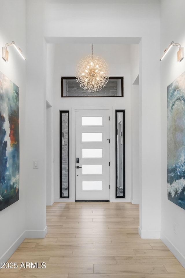 foyer entrance featuring a chandelier and light wood-type flooring