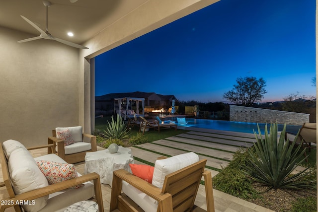 patio terrace at dusk featuring ceiling fan