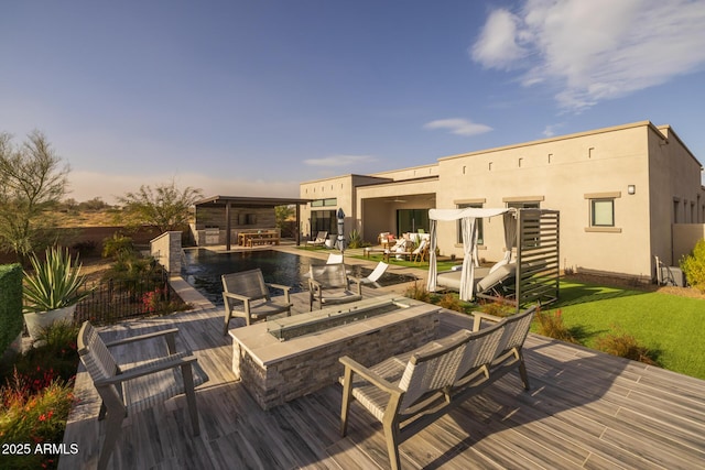 wooden terrace with a fire pit and a pool