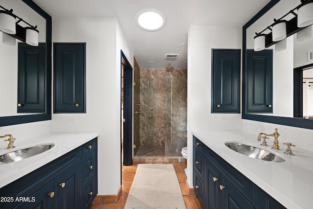 bathroom with tile patterned flooring, vanity, and a tile shower