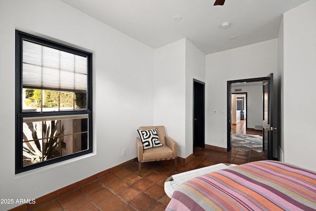 tiled bedroom featuring ceiling fan