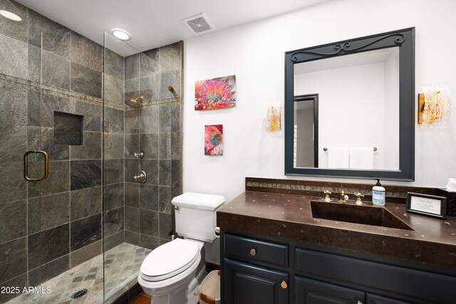 bathroom with toilet, an enclosed shower, and vanity