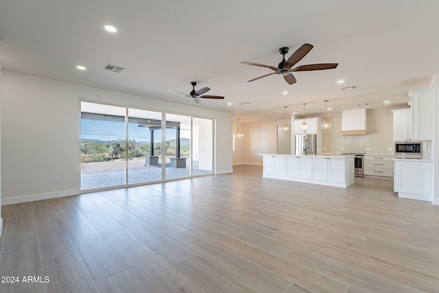 unfurnished living room with ceiling fan and light hardwood / wood-style flooring