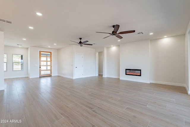 unfurnished living room with ceiling fan and light wood-type flooring