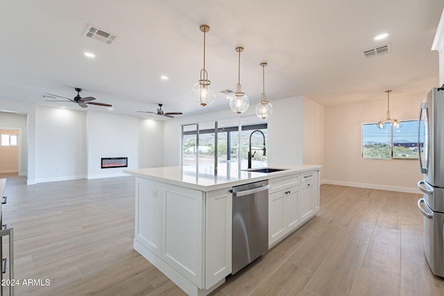 3877 S Veronica Ln, Gold Canyon, AZ 85118 - kitchen with appliances with stainless steel finishes, a sink, ceiling fan, a glass covered fireplace, and light countertops