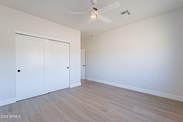 unfurnished bedroom featuring ceiling fan, a closet, and light hardwood / wood-style floors