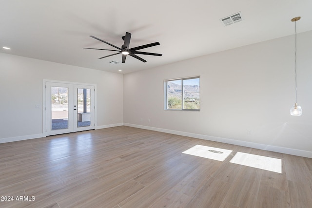 unfurnished room with ceiling fan, light wood-type flooring, and french doors