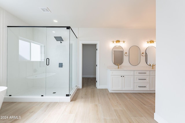 bathroom featuring hardwood / wood-style floors, vanity, and a shower with shower door