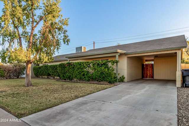 ranch-style house with a front yard and a carport