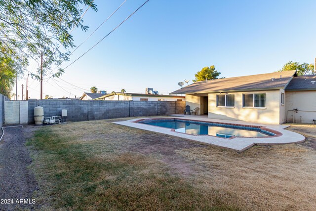 view of pool with a diving board and a yard