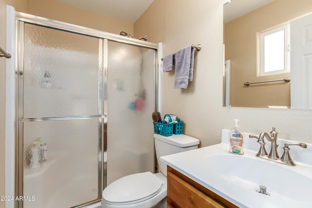 bathroom with vanity, an enclosed shower, and toilet