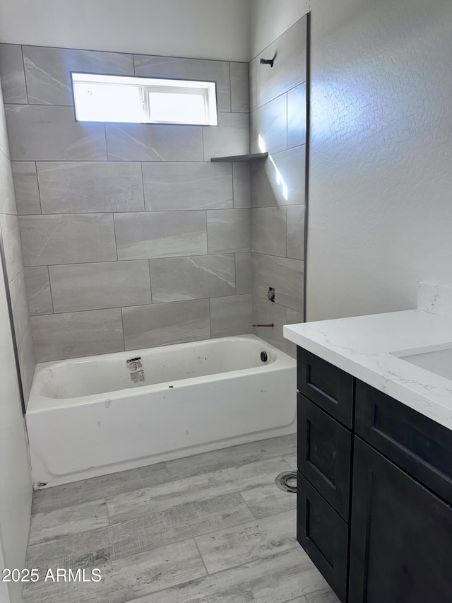 full bathroom with wood finished floors, vanity, and shower / bathtub combination