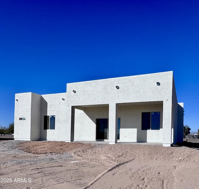 back of property featuring stucco siding