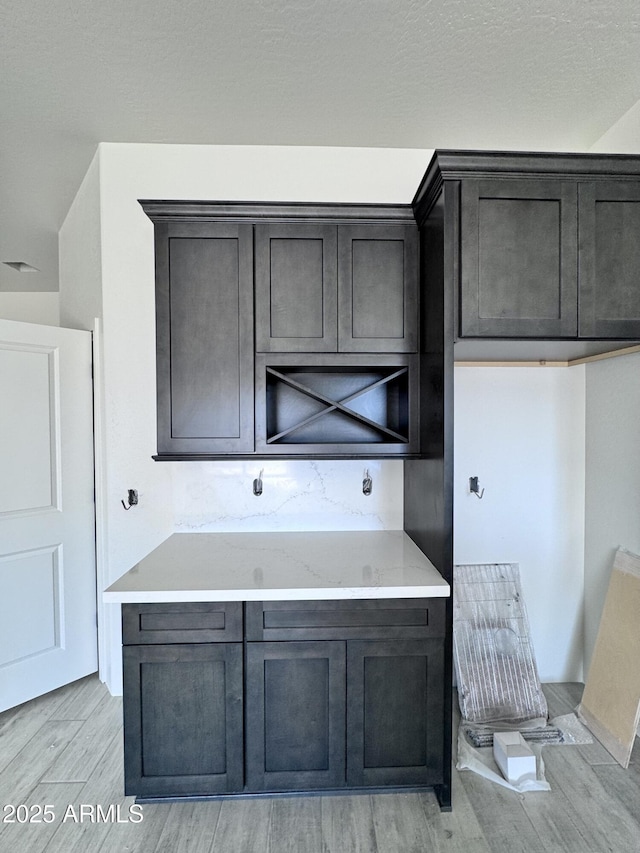 kitchen with light stone countertops and light wood-style flooring