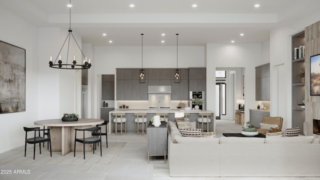 living room featuring recessed lighting, a towering ceiling, and an inviting chandelier