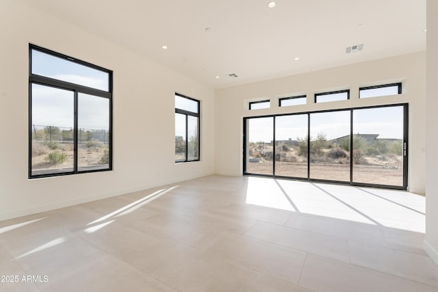 empty room with recessed lighting, plenty of natural light, visible vents, and baseboards