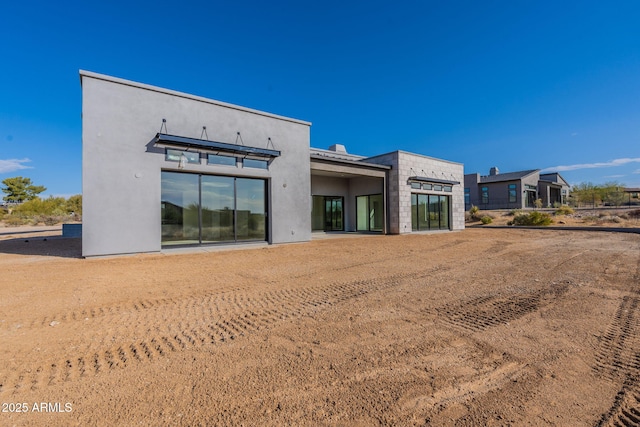 back of property featuring stucco siding