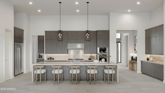 kitchen with light countertops, hanging light fixtures, a high ceiling, modern cabinets, and under cabinet range hood