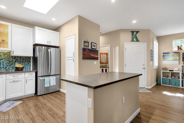 3221 N 37th St Unit 10, Phoenix, AZ 85018 - kitchen with freestanding refrigerator, dark countertops, light wood finished floors, white cabinetry, and recessed lighting