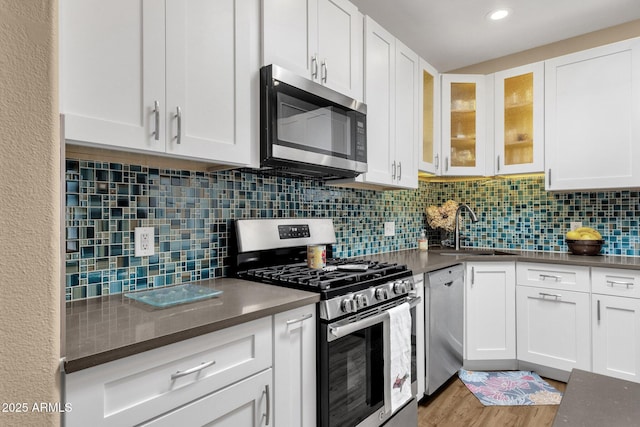 3221 N 37th St Unit 10, Phoenix, AZ 85018 - kitchen featuring stainless steel appliances, a sink, white cabinetry, light wood finished floors, and recessed lighting