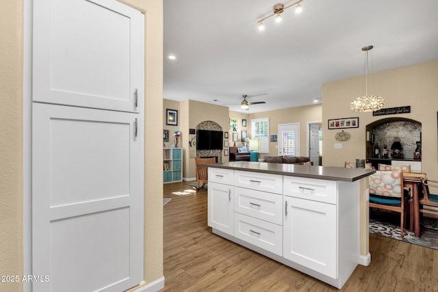 3221 N 37th St Unit 10, Phoenix, AZ 85018 - kitchen featuring dark countertops, light wood-style flooring, white cabinetry, and open floor plan