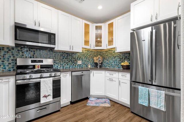 3221 N 37th St Unit 10, Phoenix, AZ 85018 - kitchen featuring appliances with stainless steel finishes, a sink, dark countertops, and white cabinetry