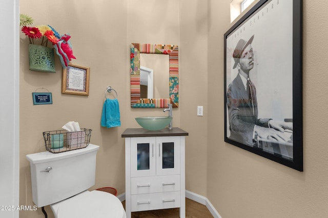 3221 N 37th St Unit 10, Phoenix, AZ 85018 - half bathroom featuring toilet, vanity, wood finished floors, and baseboards