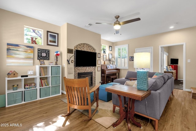 3221 N 37th St Unit 10, Phoenix, AZ 85018 - living room with wood finished floors, ceiling fan, baseboards, and a glass covered fireplace