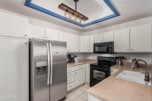 kitchen with pendant lighting, black appliances, white cabinets, sink, and light tile patterned floors