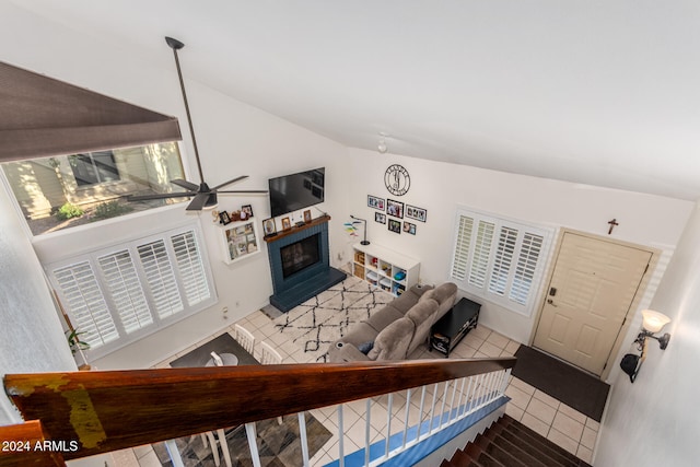 tiled living room with ceiling fan and vaulted ceiling